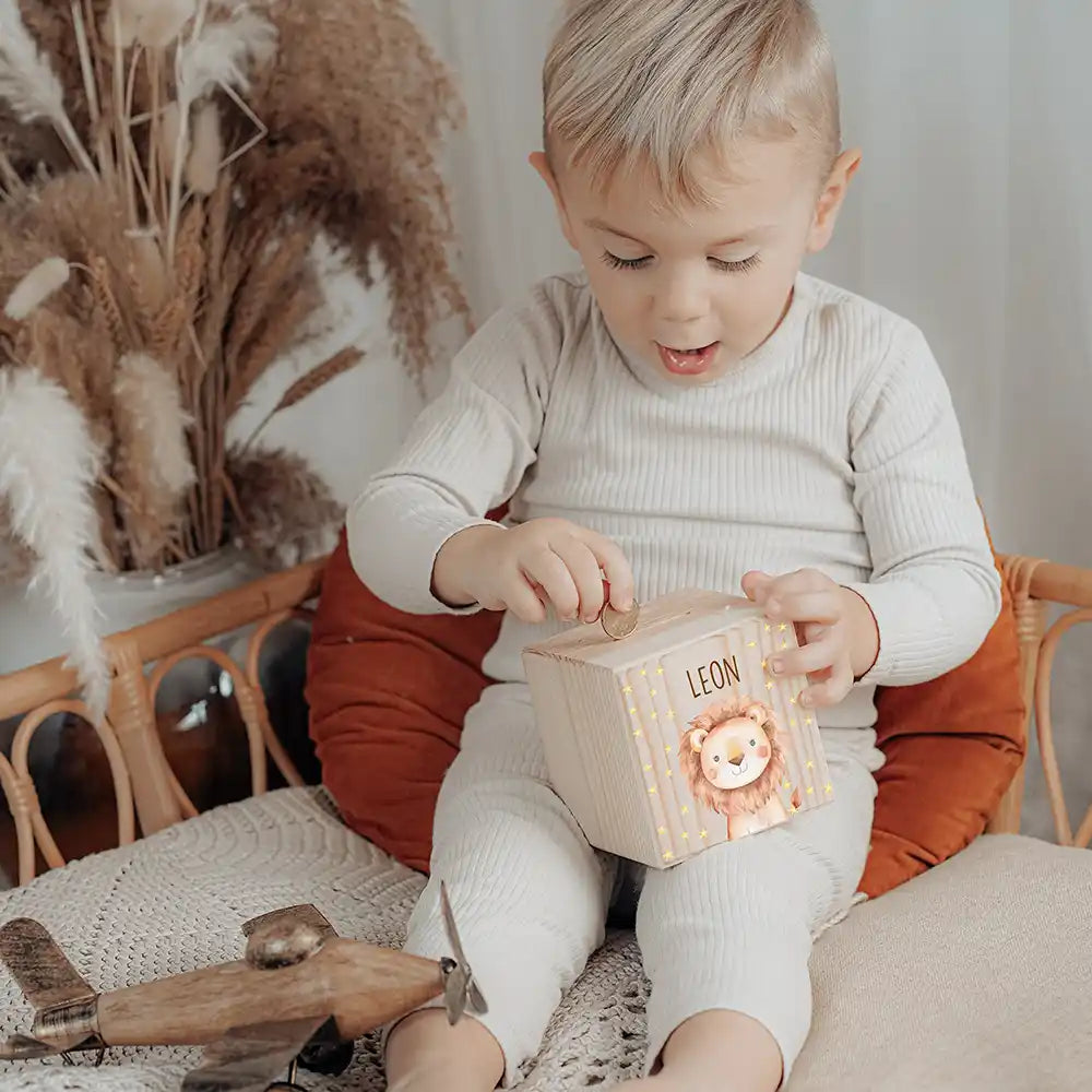 Enfant glissant une pièce dans sa tirelire personnalisée en bois — Kidsmood